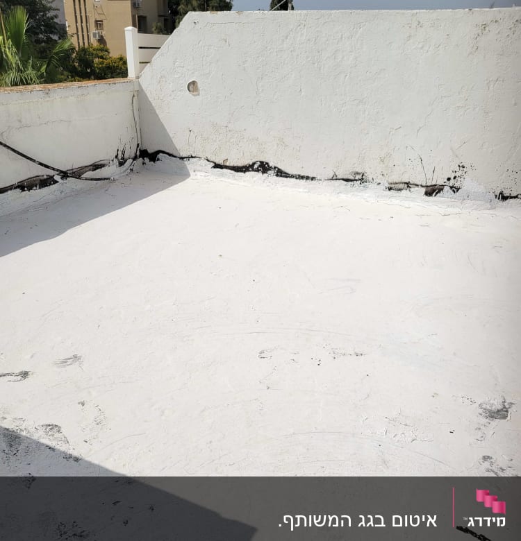 גג אטום עם שכבת איטום לבנה ושוליים שחורים